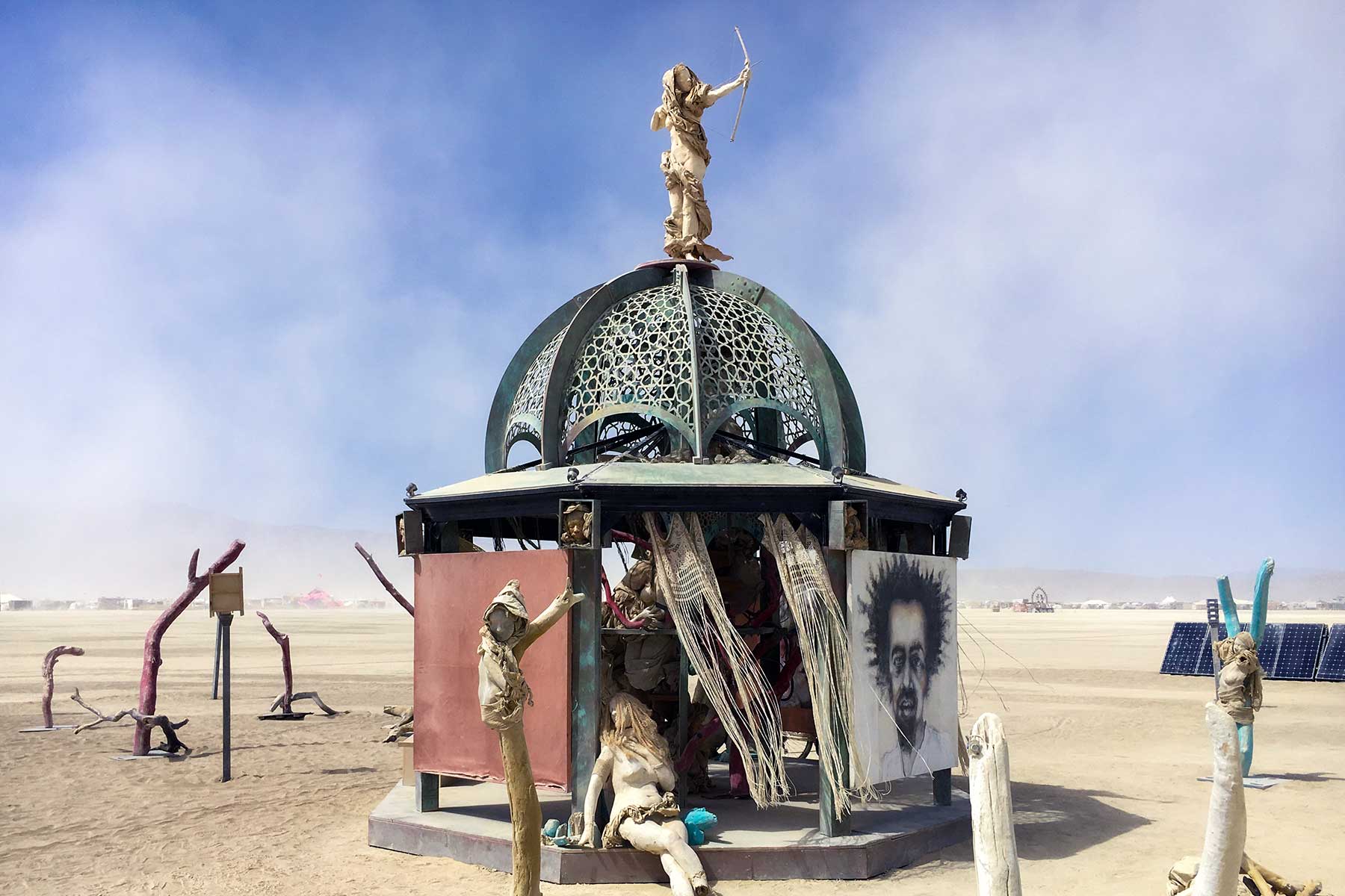 Secretly Abandoned Spaces by day: a domed pavilion with an archer figure on top, surrounded by cast figures under a dusty sky